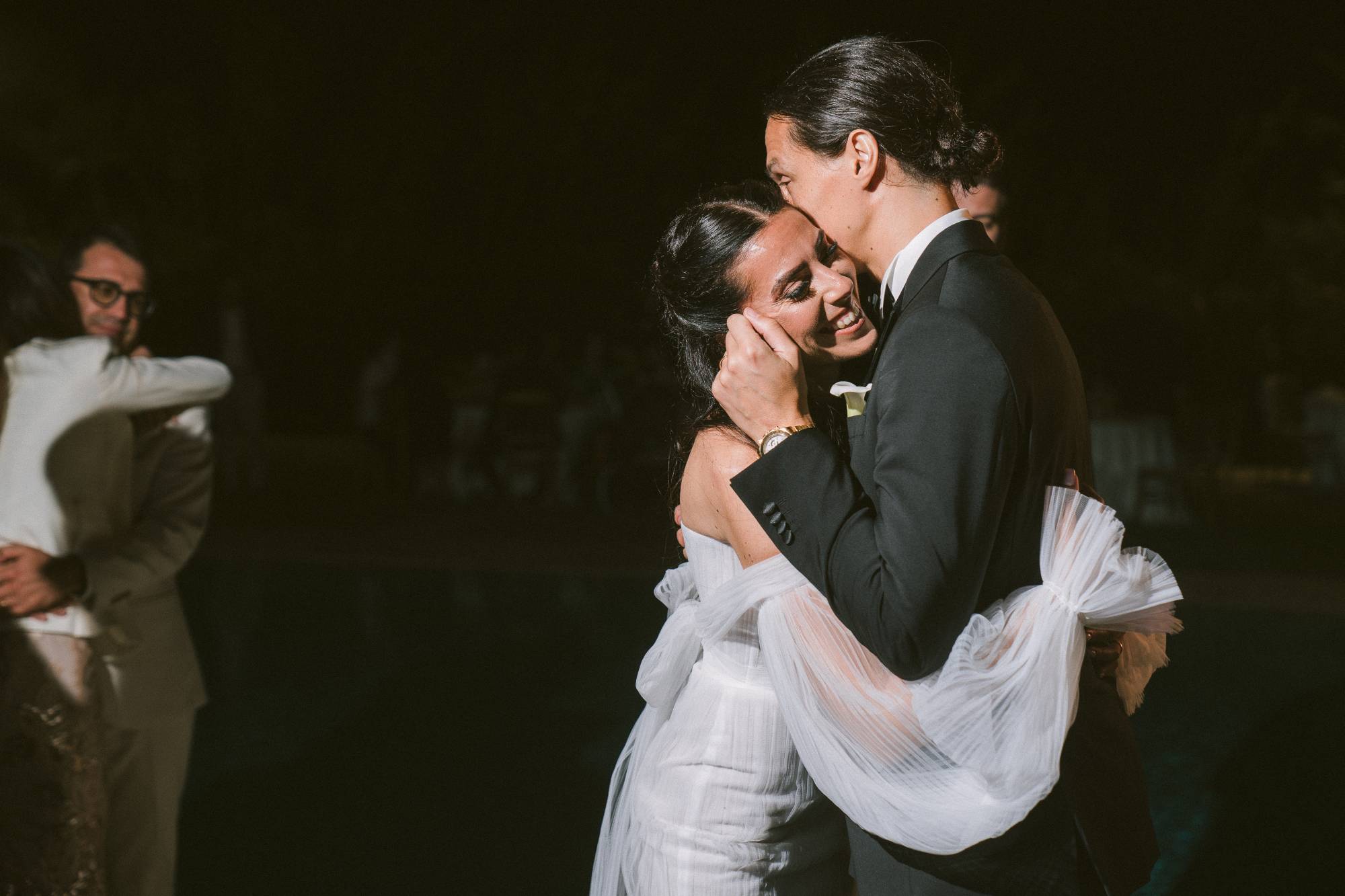 Primo ballo notturno: Andrea bacia Marianna sulla guancia, lei sorride emozionata, atmosfera intima a luci basse